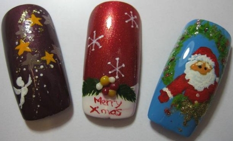 Trei unghii decorate: cea din stânga, mov închis, cu steluțe aurii și un înger alb; cea din mijloc, roșie, cu fructe de ilice și mesajul „Merry Xmas”; cea din dreapta, albastră, cu Moș Crăciun lângă o coroniță.